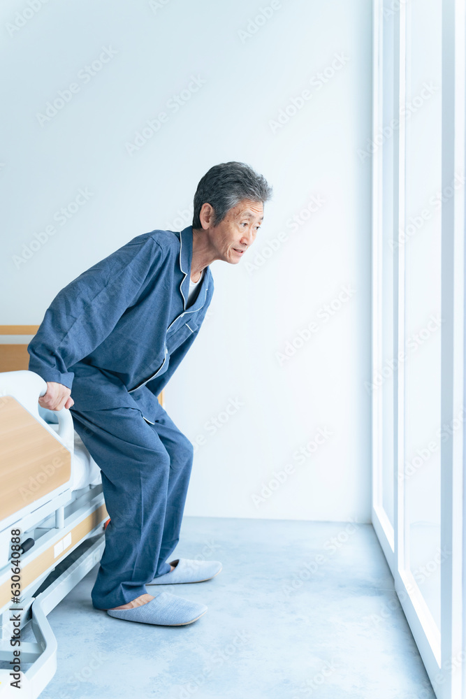 介護ベッドから立ち上がるシニア男性
