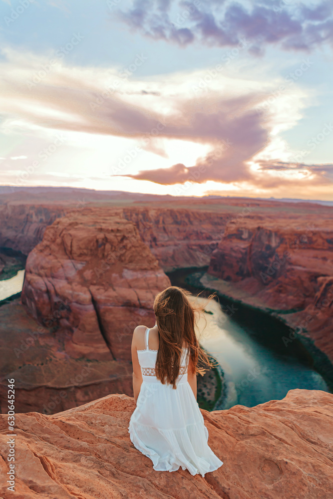 Happy girl on the edge of the cliff at Horseshoe Band Canyon in Page, Arizona. Adventure and tourism concept. Beautiful nature in USA