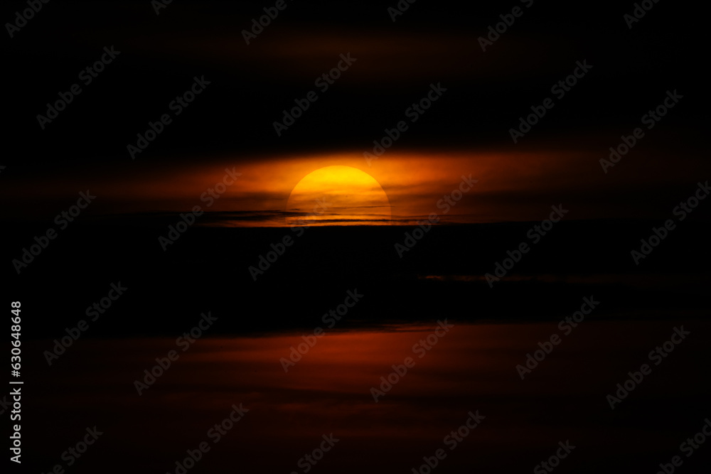Close up view of sun rising up in the morning through the clouds. Sunspots on the sun, sunrise concept photo.