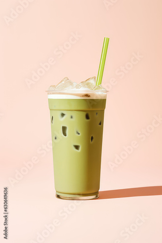 Matcha iced tea with ice cubes, in a glass isolated on a pastel light pink background. Vertical format for stories. 