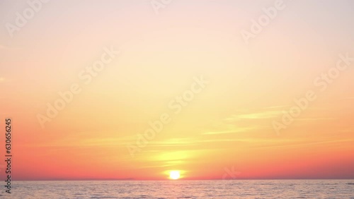 Dramatic amazing picturesque colorful sunset over ocean with sun in center and calm water sufrace. Burning sky and shining golden sun. Summer sunset seascape. Atlantic Ocean beach sunsets. photo