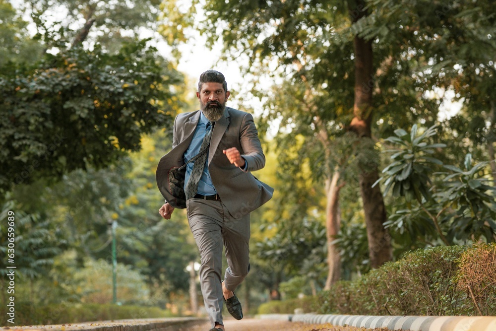 Indian corporate man running at park. Indian corporate man running at park.