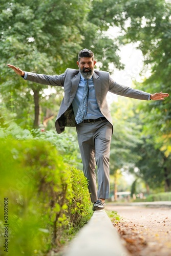 Indian businessman walking at park and giving happy expression