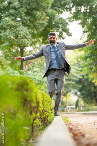 Indian businessman walking at park and giving happy expression