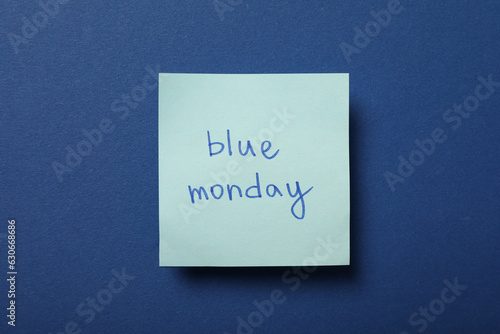 Paper with blue Monday text on dark blue background, top view