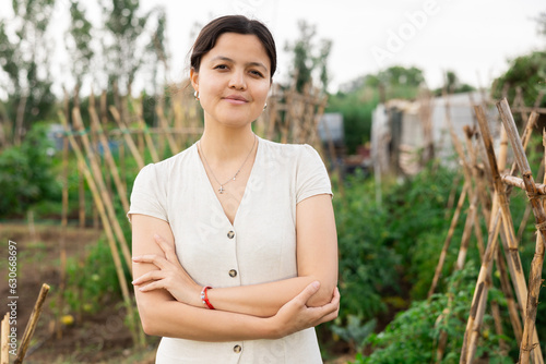 Portrait of a young positive girl in her garden on a summer day photo
