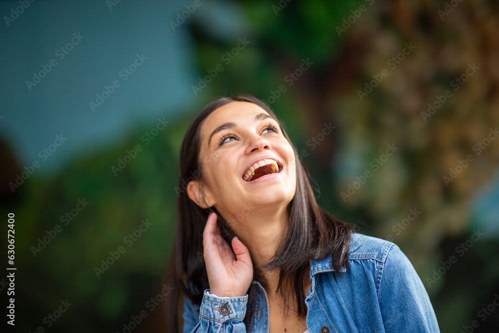 Close up happy young woman laughing and looking up Close up happy young woman laughing and looking up
