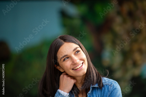 Close up smiling young woman thinking