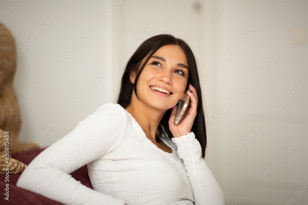 smiling young woman relaxing at home talking with mobile phone smiling young woman relaxing at home talking with mobile phone
