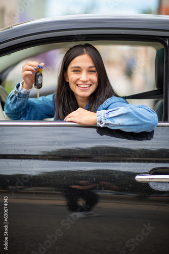 smiling young woman with keys in hand