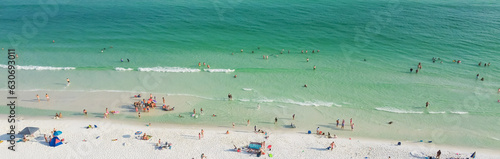 Panorama aerial view Destin beaches with crowded beach umbrella, people swimming relaxing on sugar-white sand beaches, turquoise water, gorgeous shade blue waves in South Walton, Florida, USA