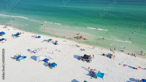 Beautiful sugar-white sand beaches and row of beach umbrella with family people gathering, relaxing, swimming on turquoise water, gorgeous shade blue waves in South Walton, Florida, USA © trongnguyen