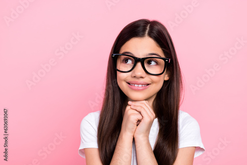 Photo portrait of cute schoolgirl hands touch chin look empty space idea wear trendy white outfit isolated on pink color background