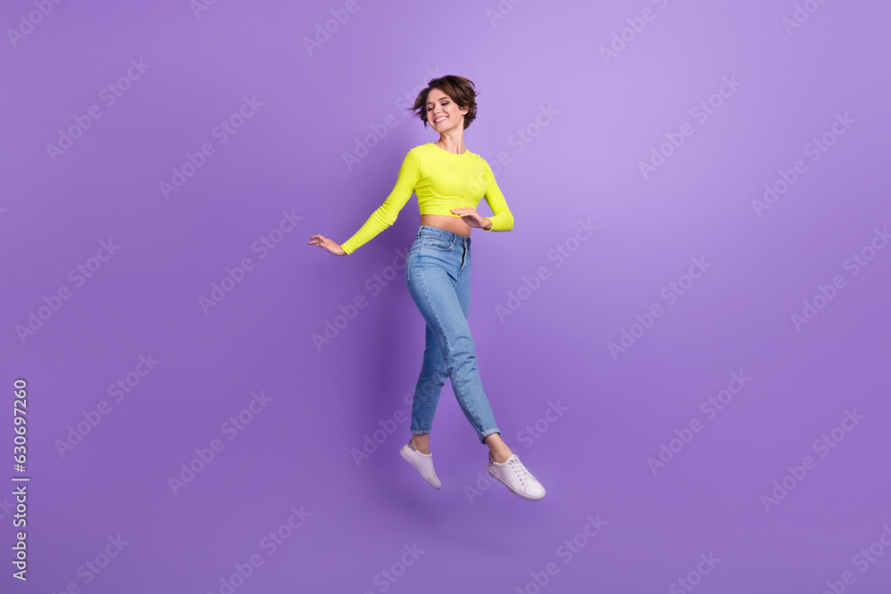 Full size portrait of pretty peaceful carefree slender girl jumping running isolated on purple color background