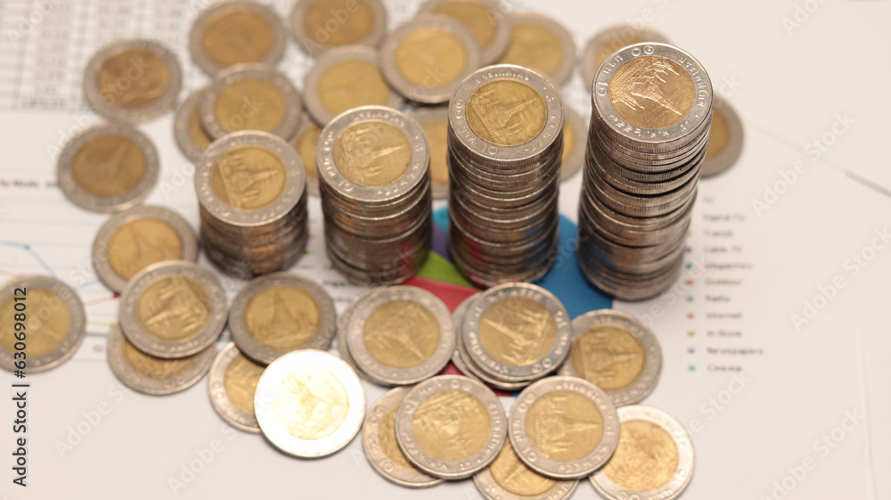 Pile of money or coins with graph paper is the background,Business growth concept,Concept for account and finance Pile of money or coins with graph paper is the background,Business growth concept,Concept for account and finance