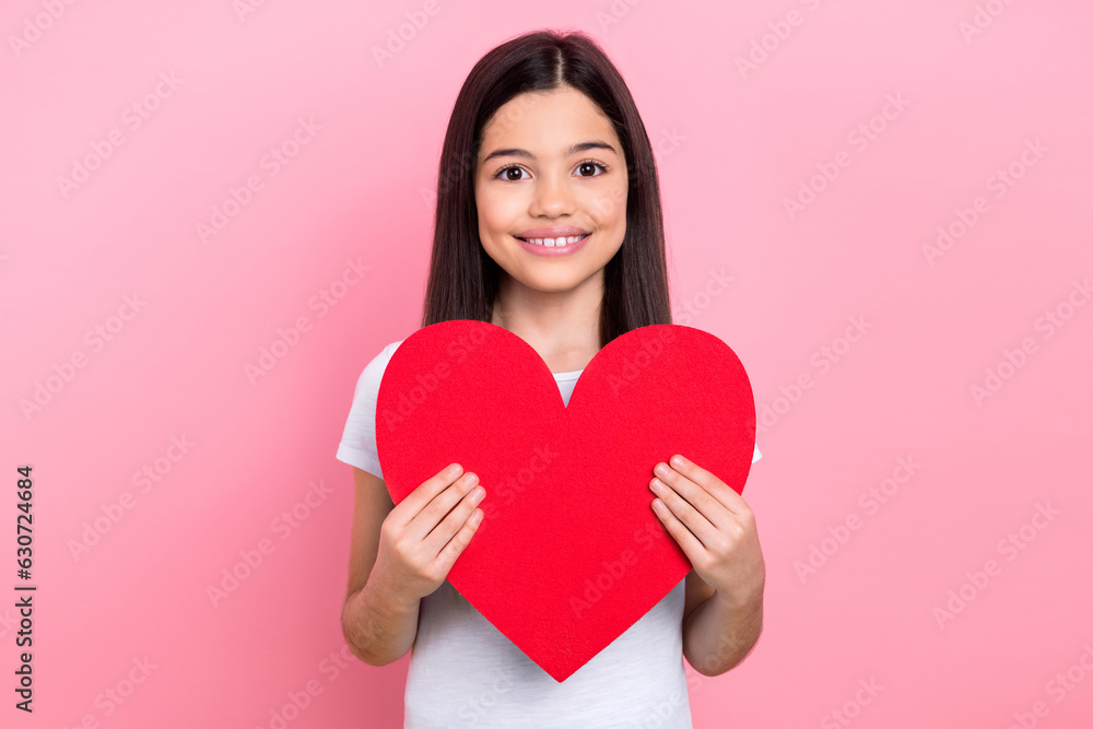 Photo portrait of cute schoolgirl toothy beaming smile hold large red heart wear trendy white outfit isolated on pink color background