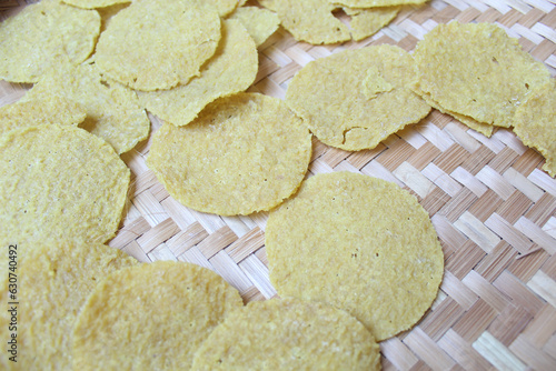 Kerupuk Nasi, Kerupuk Gendar or Rice Crackers, before fried. Food from Indonesia. Round shape. On a woven bamboo tray photo