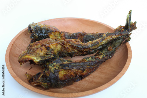 Fried catfish on a wooden plate, isolated on white background photo