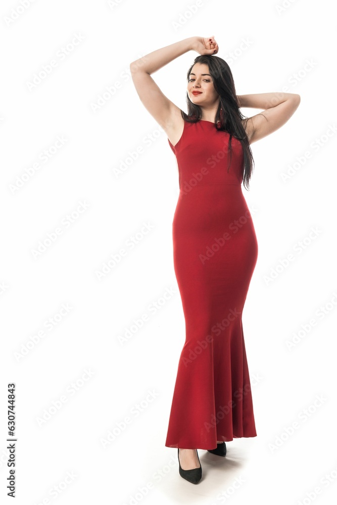 Young Caucasian woman in a red dress and matching high heels standing against a white background