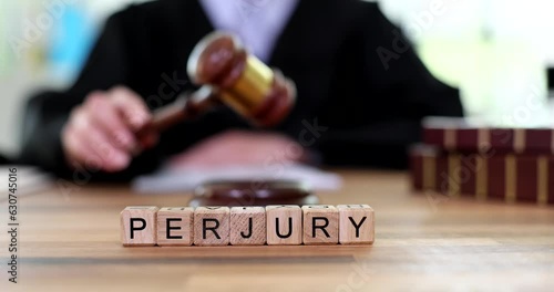 Judicial gavel of justice with text of perjury at judge. Crime consisting in knowingly giving false information to law enforcement agencies courts or authorities photo