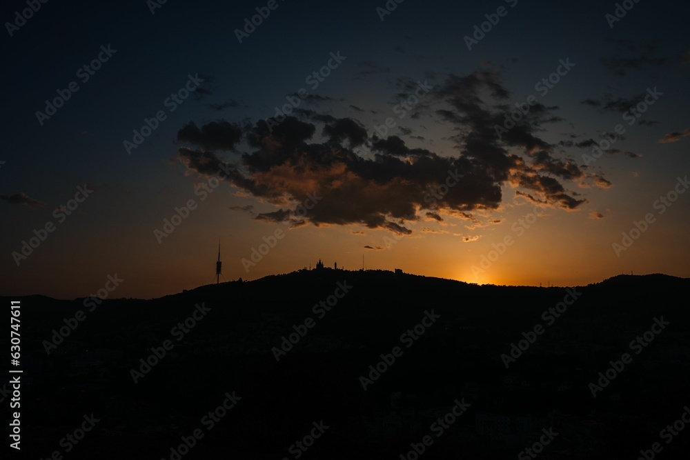 Scenic vista of an orange and yellow-hued sunset sky in Barcelona from the top of Carmel hill