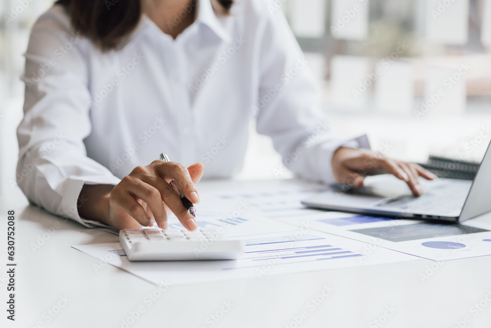 Businesswoman working with laptop and analyzing financial and accounting documents. Business woman working in finance and accounting Analyze financial budget in the office. Businesswoman working with laptop and analyzing financial and accounting documents. Business woman working in finance and accounting Analyze financial budget in the office.