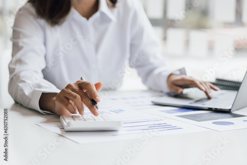 Businesswoman working with laptop and analyzing financial and accounting documents. Business woman working in finance and accounting Analyze financial budget in the office.