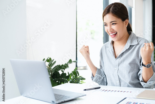 Quadro su tela Smiling beautiful business asian woman working on office desk computer