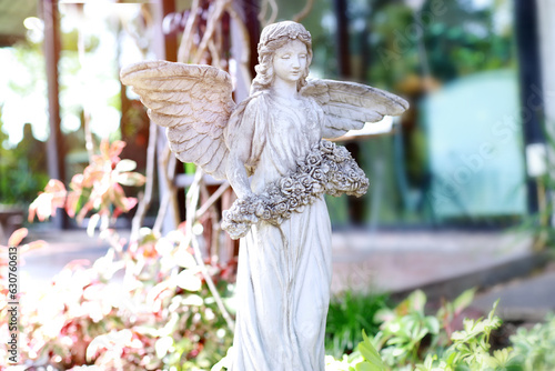 statue of a marble winged angel adorns the garden,Roman style female statue in the park.