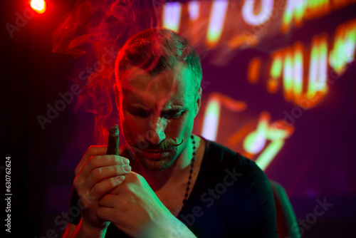 Thoughtful man smoking cigar in modern nightclub interior