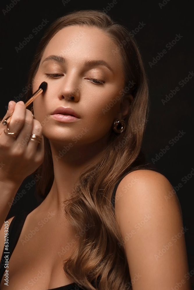 Beautiful young woman with a light natural make-up, brush for cosmetics and perfect skin.