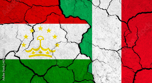 Flags of Tajikistan and Italy on cracked surface - politics  relationship concept