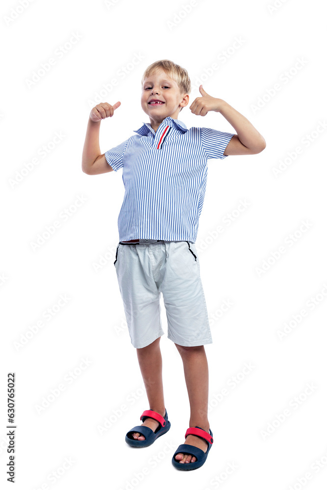 A laughing boy in shorts and a striped shirt is standing and thumbs up. Positivity and confidence. Full height. Isolated on white background. Vertical. A laughing boy in shorts and a striped shirt is standing and thumbs up. Positivity and confidence. Full height. Isolated on white background. Vertical.