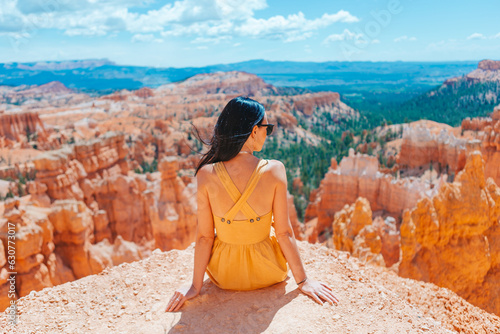 Hiker woman in Bryce Canyon resting enjoying view in beautiful nature landscape with hoodoos, pinnacles and spires rock formations in Utah
