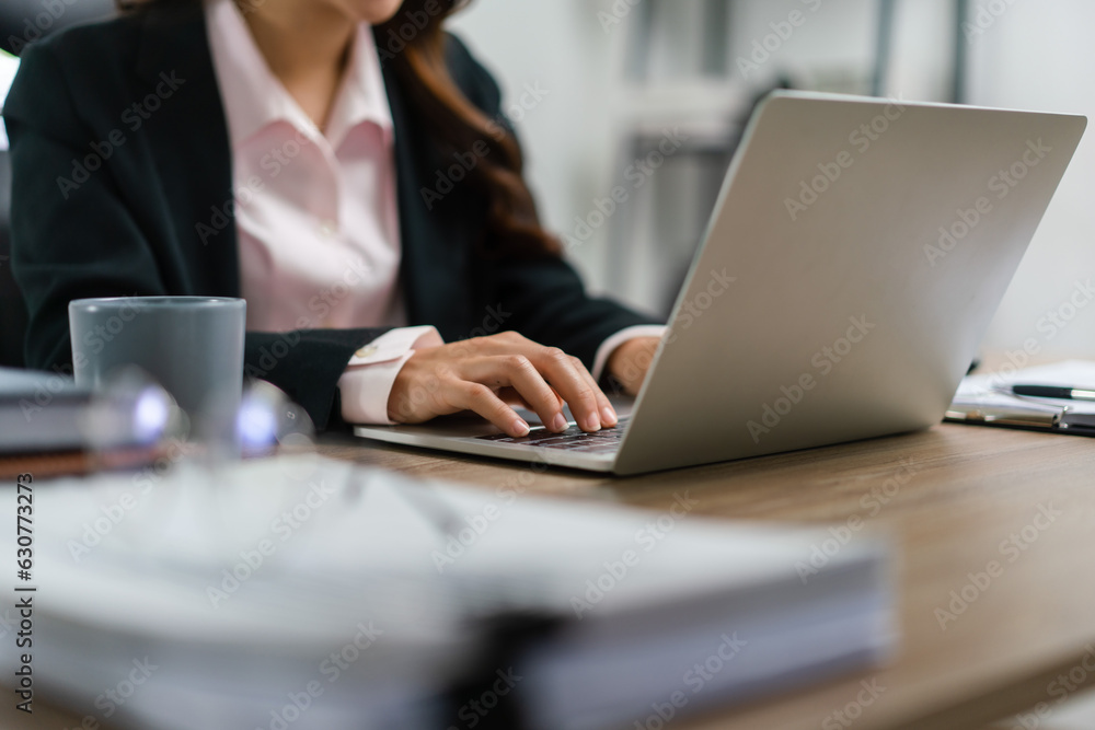 Businesswoman thinking about marketing plan of new startup project and typing data on laptop Businesswoman thinking about marketing plan of new startup project and typing data on laptop