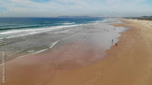 Caparica beach near Lisboa Portugal. Long sandy beach at Atlantic ocean. Aerial drone view. Flying over. High quality 4k footage