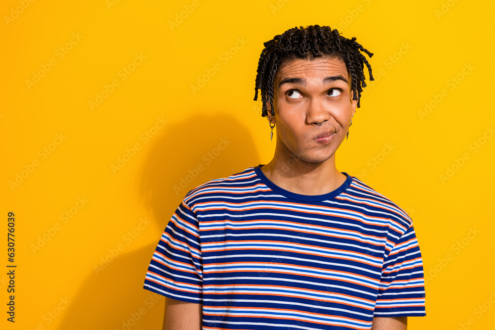 Photo of minded guy wear trendy clothes piercing look empty space hmm suspicious proposition news isolated on yellow color background Photo of minded guy wear trendy clothes piercing look empty space hmm suspicious proposition news isolated on yellow color background