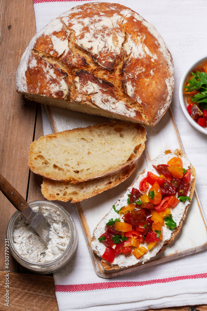Bruschetta from homemade bread with cottage cheese and sprat pate and tomatoes on a wooden background. Rustic style.