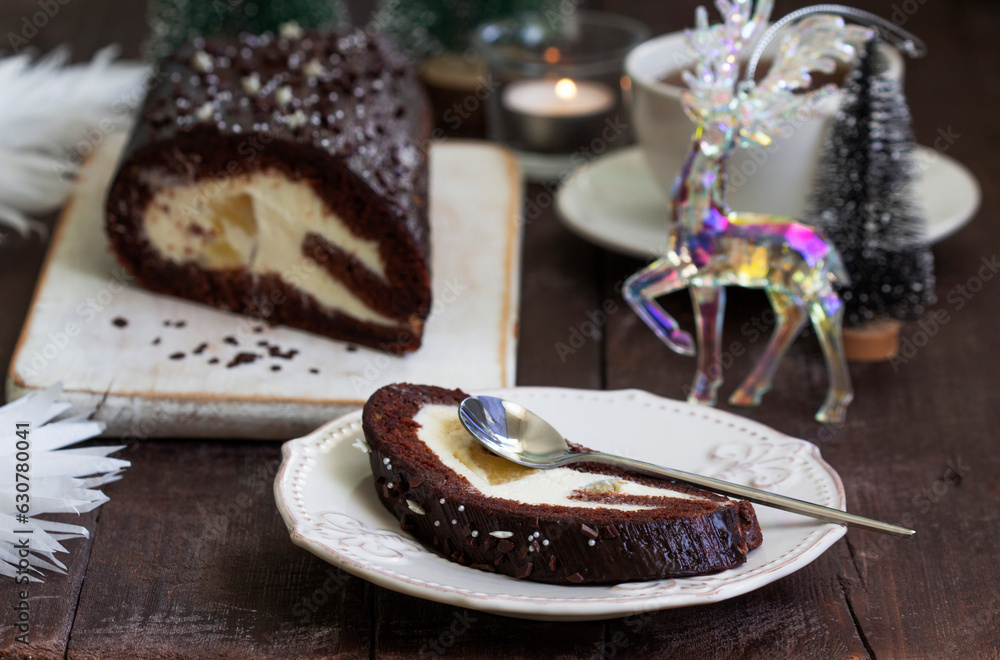 Chocolate roll stuffed with butter cream and pineapple on a Christmas background. Rustic style.