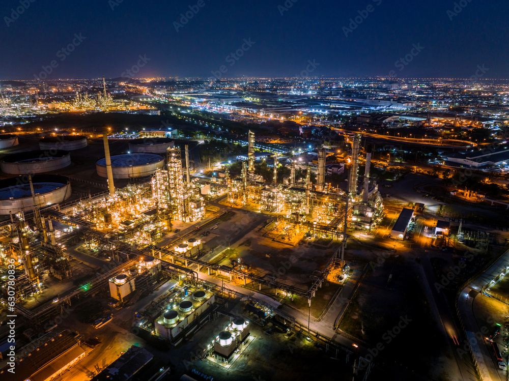 Naklejka premium Aerial view of the petrochemical, oil and gas industry. Industrial field, oil refinery storage tanks and steel pipelines at night, ecology and health.