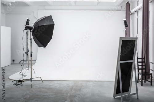 interior of bright space of photo studio with large white cyclorama with lighting equipment photo