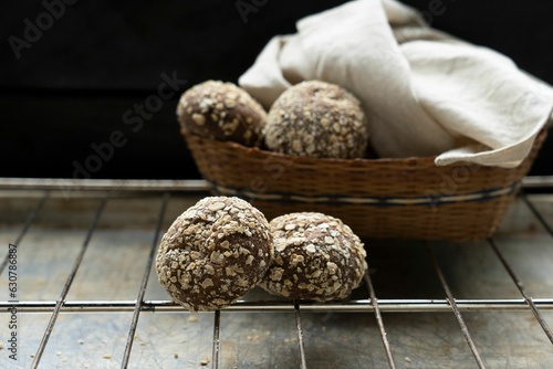 Freshly-baked, round brownies on a rustic wooden bowl placed on top of a metallic cooling rack