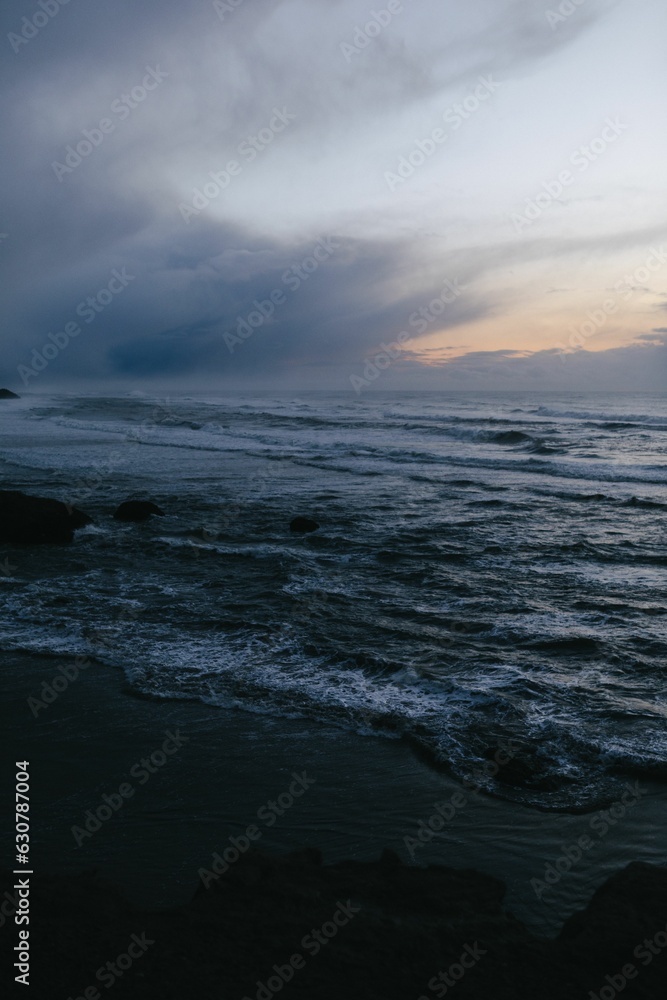 Moody sunset photo of the ocean from the Pacific Coast Highway with rich blue and purple colors.