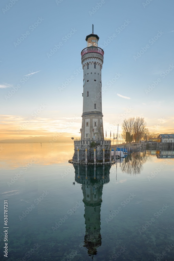 Lighthouse with boats nearby in Harbour of Lindau in Germany at sunset