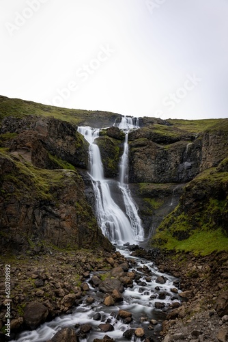 Fototapeta Naklejka Na Ścianę i Meble -  Vibrant Rjukandi waterfall cascading down a lush green hillside