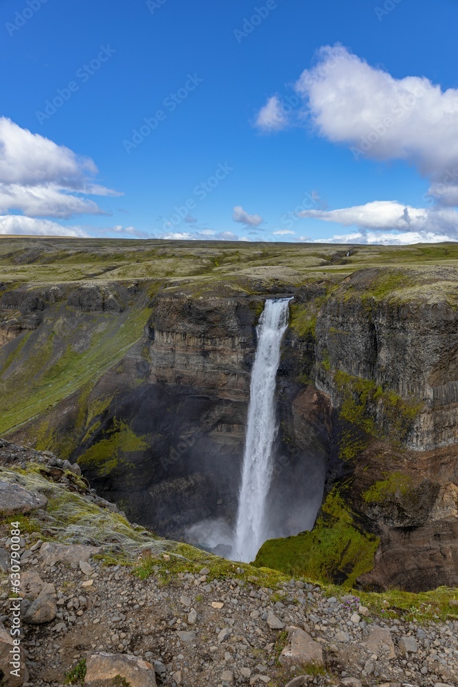 Fototapeta premium Scenic landscape featuring the Haifoss waterfall cascading over a rocky hillside