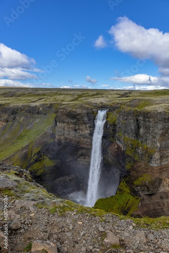 Scenic landscape featuring the Haifoss waterfall cascading over a rocky hillside