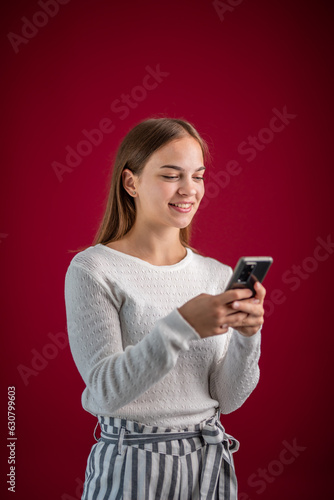 young woman uses mobile phone on purple background