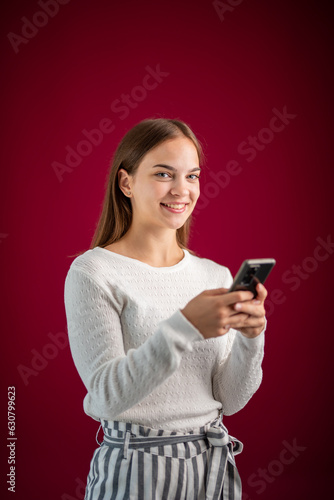 young woman uses mobile phone on purple background