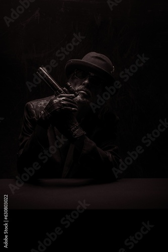 Dramatic portrait of a gangster holding a gun. photo